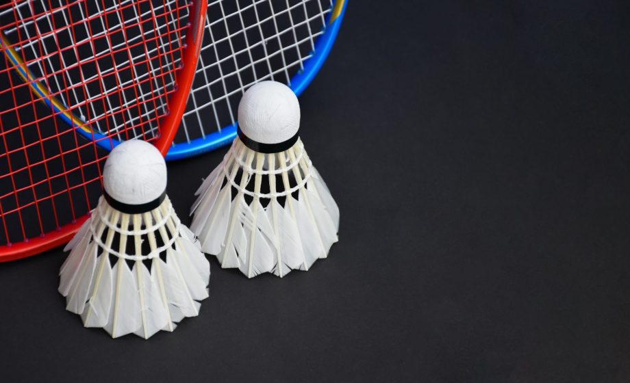 Cream,White,Badminton,Shuttlecocks,And,Rackets,On,Black,Floor,In